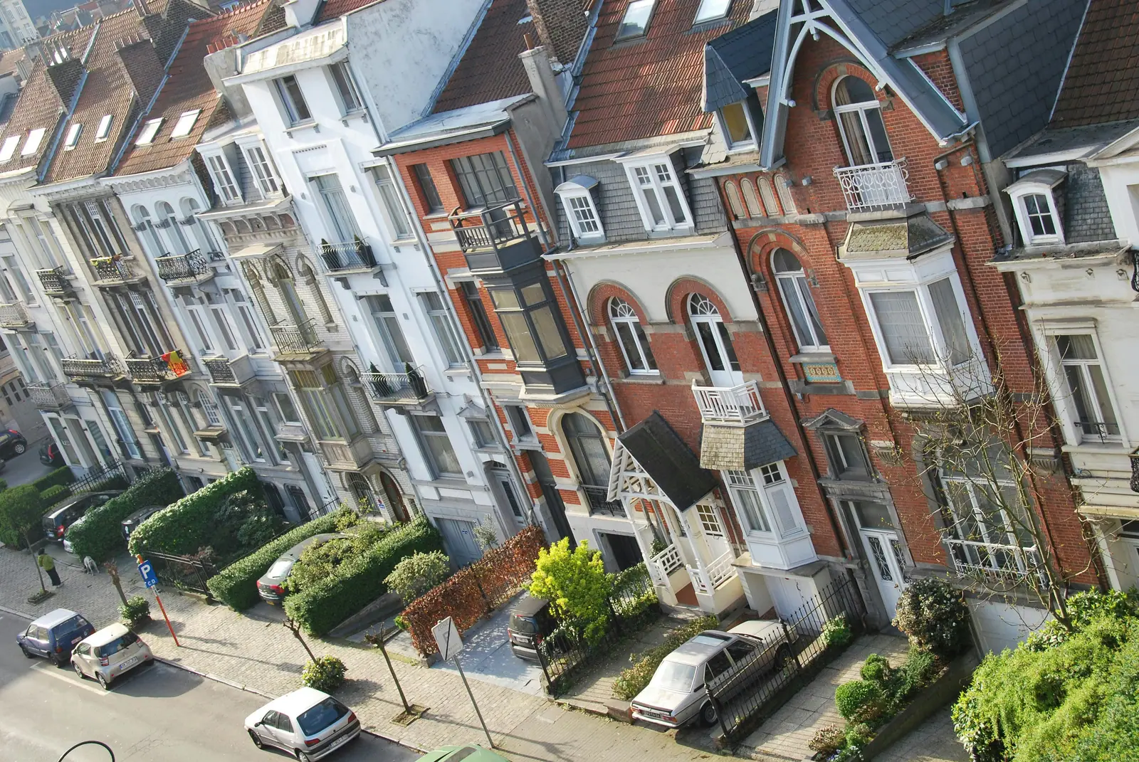 Rue bruxelloise bordée de maisons de ville en brique et façades Art nouveau